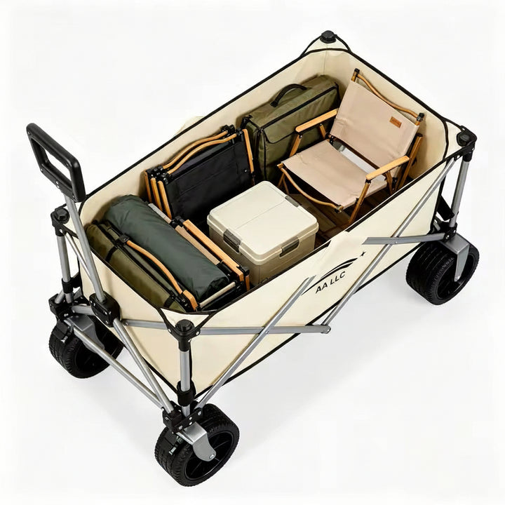 A silver and beige folding utility wagon with black wheels, shown loaded with camping gear including a folding chair, cooler, bags, and rolled gear on a clean white background.